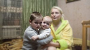 Goncharova Iryna, beneficiary of a house rebuilt program me of the Luxembourg Red Cross, posses for the photo with her sons in Sloviansk, Donetsk area, Ukraine.